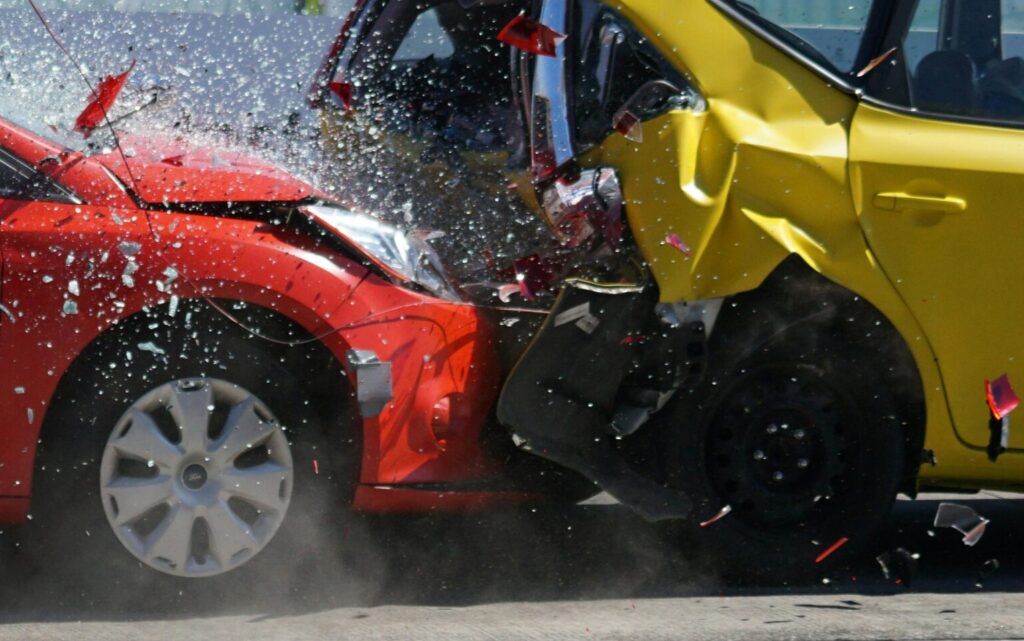 Red and yellow cars shown in a head-on collision during a crash test for safety evaluation.
